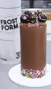A tall smooth cake with a sharp top edge